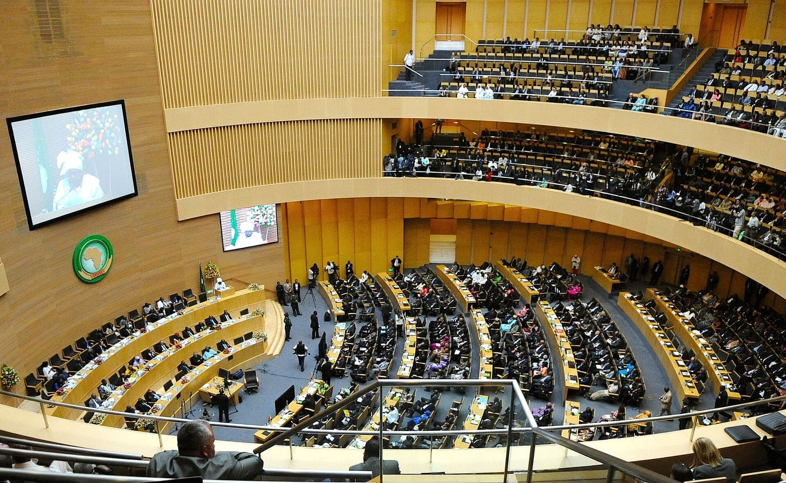 A large circular assembly hall filled with delegates.
