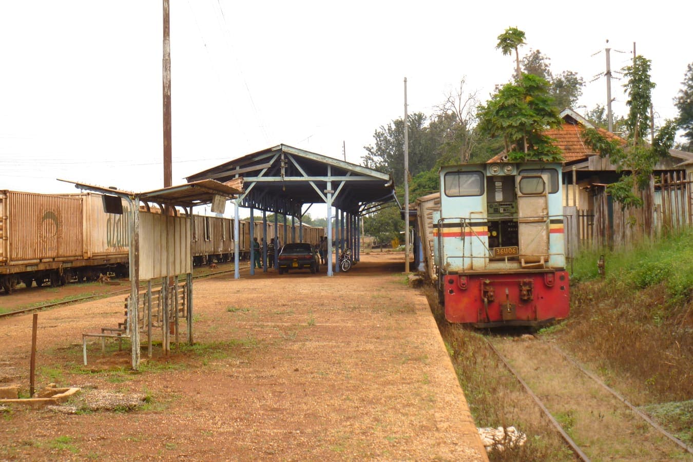 Railway tracks, a covered platform and a locomotive at a small station.