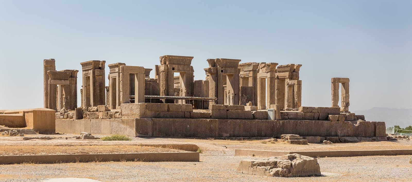 Stone columns and gateways standing among the ruins of Persepolis.